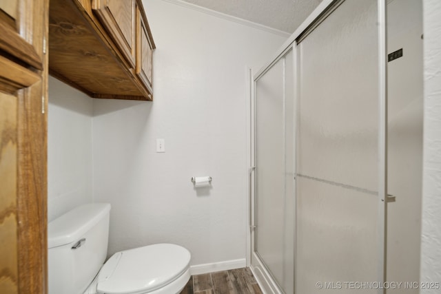 11462 Red Fox Ln, Sperry, OK 74073 - bathroom with wood finished floors, toilet, a shower stall, baseboards, and ornamental molding