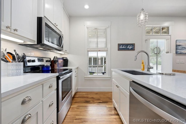 43 Center Ln S, Carlton Landing, OK 74432 - kitchen with appliances with stainless steel finishes, a sink, light countertops, white cabinets, and light wood-style flooring