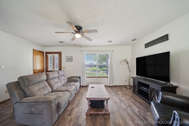 living room featuring a textured ceiling, a ceiling fan, wood finished floors, and baseboards