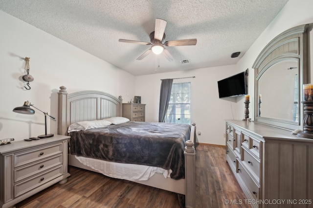 bedroom featuring a textured ceiling, dark wood-type flooring, and ceiling fan