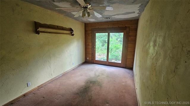 empty room featuring light carpet, ceiling fan, and baseboards