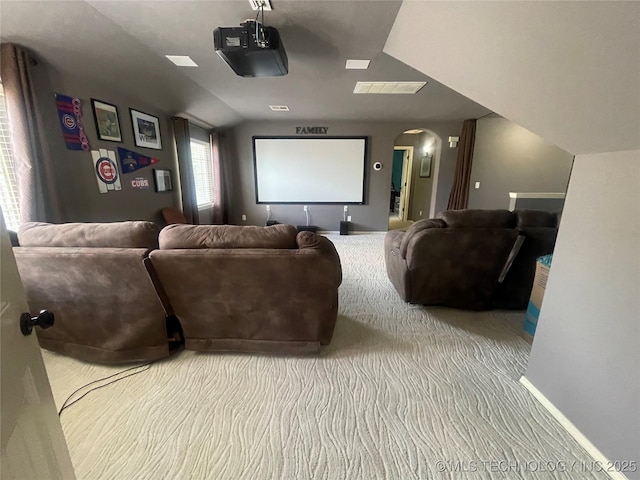cinema room featuring arched walkways, carpet floors, and baseboards