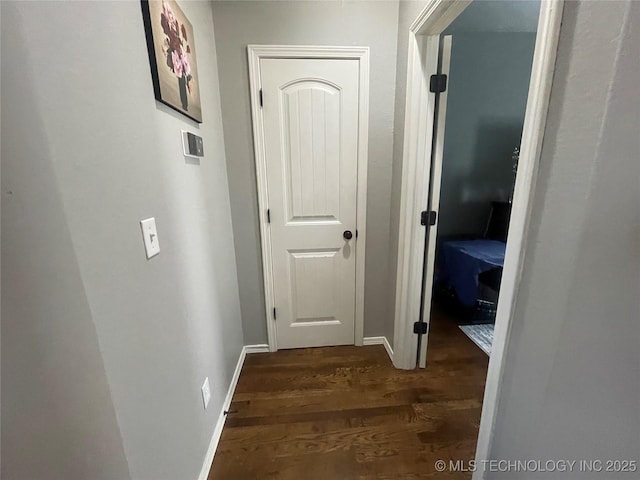 hallway featuring wood finished floors and baseboards