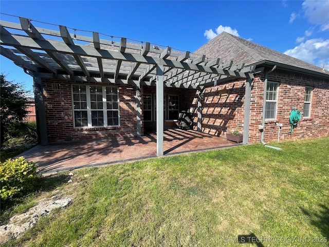 rear view of house featuring a patio area, a lawn, a pergola, and brick siding