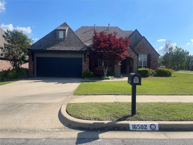 view of front facade with a front yard, concrete driveway, brick siding, a garage, and a shingled roof