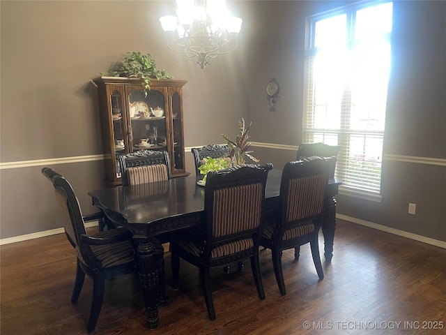dining area featuring a chandelier, wood finished floors, and baseboards
