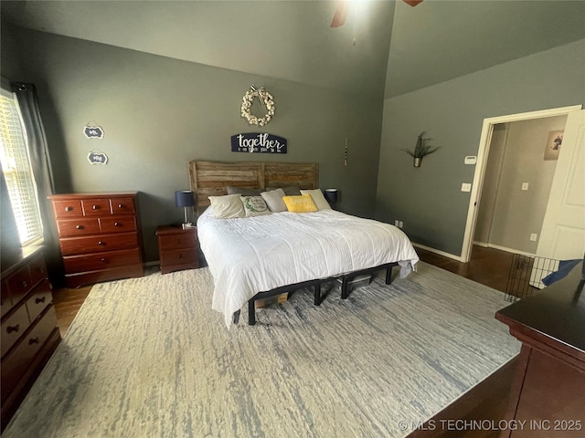 bedroom with vaulted ceiling, wood finished floors, ceiling fan, and baseboards