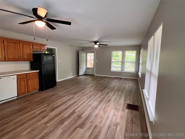 140 Oaks Rd, Eucha, OK 74342 - kitchen featuring freestanding refrigerator, dishwasher, ceiling fan, brown cabinets, and wood finished floors