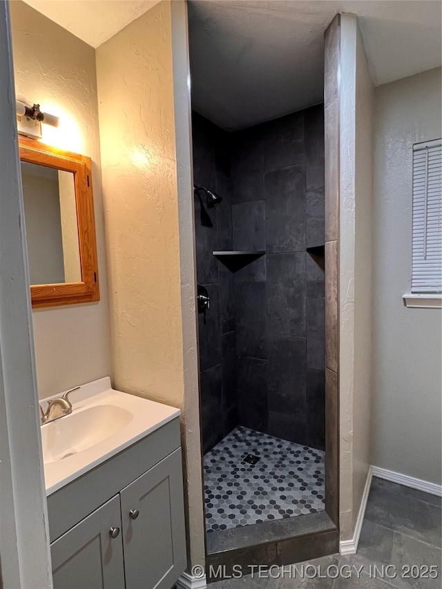 140 Oaks Rd, Eucha, OK 74342 - bathroom featuring a tile shower, vanity, a textured wall, and baseboards