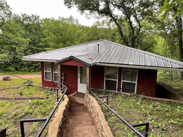 140 Oaks Rd, Eucha, OK 74342 - view of front of home with metal roof, stucco siding, and a forest view