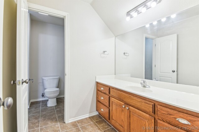3909 W Utica St, Broken Arrow, OK 74011 - bathroom with toilet, vanity, baseboards, and vaulted ceiling