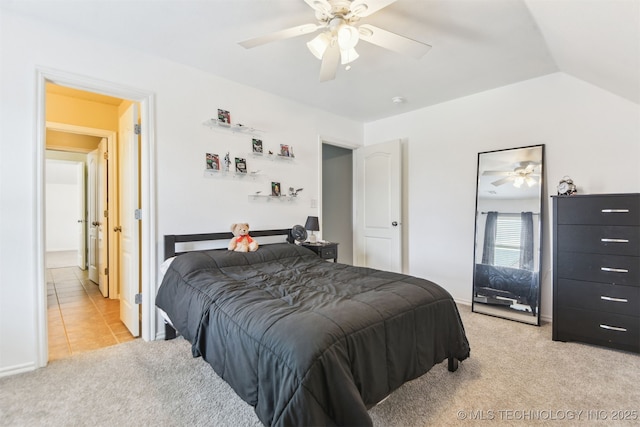 bedroom with light carpet, a ceiling fan, vaulted ceiling, and light tile patterned flooring