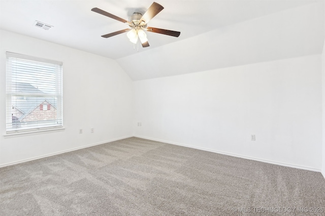 carpeted empty room with ceiling fan, lofted ceiling, and baseboards