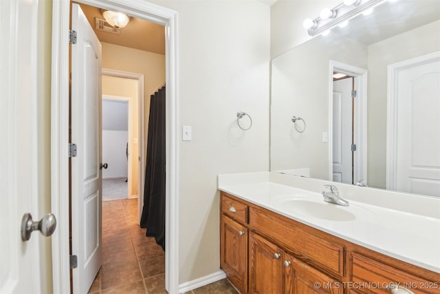 bathroom with tile patterned floors, vanity, and baseboards