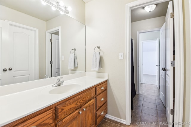 bathroom featuring vanity, tile patterned flooring, and baseboards