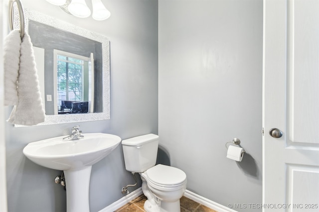 bathroom featuring toilet and baseboards