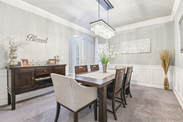 3909 W Utica St, Broken Arrow, OK 74011 - carpeted dining area with a chandelier, arched walkways, a decorative wall, ornamental molding, and a wainscoted wall