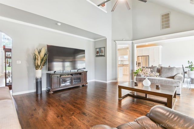 3909 W Utica St, Broken Arrow, OK 74011 - living area featuring arched walkways, a ceiling fan, high vaulted ceiling, dark wood-type flooring, and baseboards