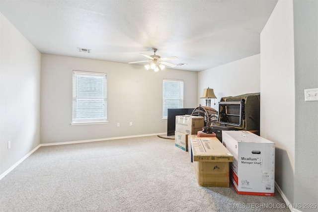 interior space featuring healthy amount of natural light, a ceiling fan, and baseboards