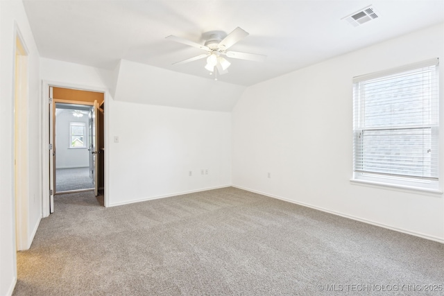 empty room featuring carpet, ceiling fan, baseboards, and vaulted ceiling