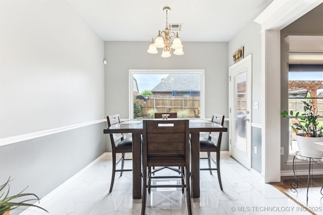 3909 W Utica St, Broken Arrow, OK 74011 - dining area with a chandelier, light marble finish floors, and baseboards