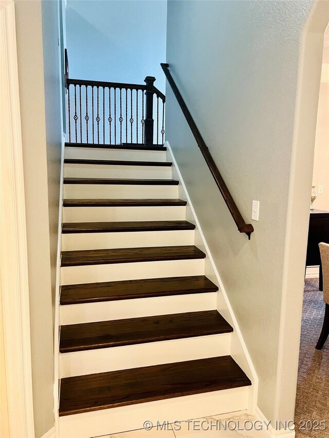 stairs with arched walkways and carpet flooring