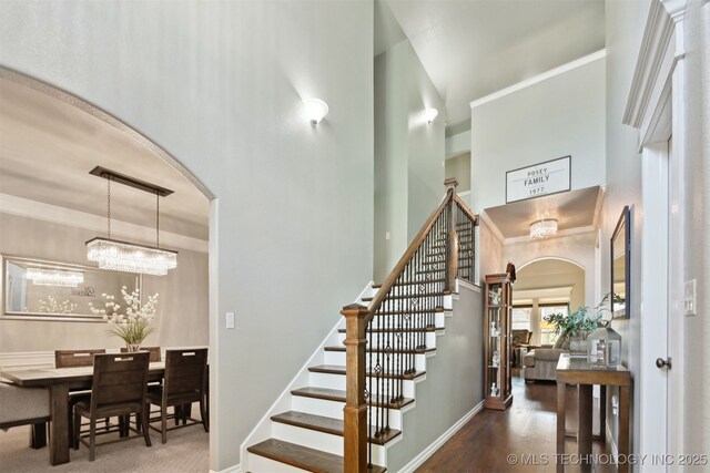 3909 W Utica St, Broken Arrow, OK 74011 - staircase featuring arched walkways, a high ceiling, baseboards, ornamental molding, and wood finished floors