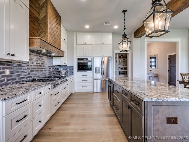 3241 E 171st St S, Bixby, OK 74008 - kitchen with stainless steel appliances, a chandelier, custom range hood, white cabinets, and a center island