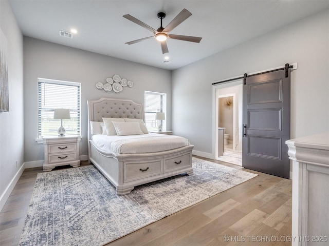 3241 E 171st St S, Bixby, OK 74008 - bedroom with a barn door, wood finished floors, ensuite bathroom, a ceiling fan, and baseboards
