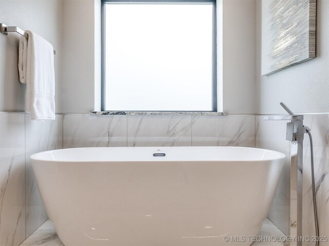 3241 E 171st St S, Bixby, OK 74008 - bathroom with tile walls, wainscoting, and a soaking tub