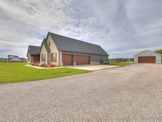 3241 E 171st St S, Bixby, OK 74008 - view of side of home with a detached garage, a lawn, roof with shingles, an outdoor structure, and driveway