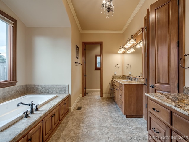 full bathroom featuring a garden tub, vanity, crown molding, and a chandelier