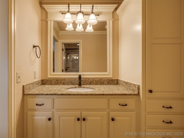 bathroom with vanity, crown molding, and a chandelier