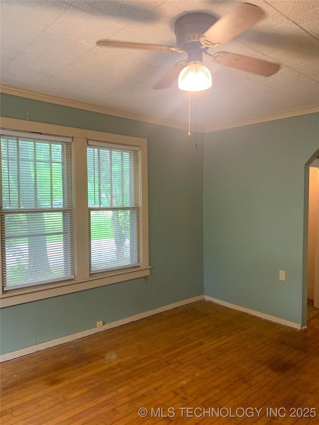 303 W Conklin, Sparks, OK 74869 - empty room with a ceiling fan, wood finished floors, crown molding, arched walkways, and baseboards