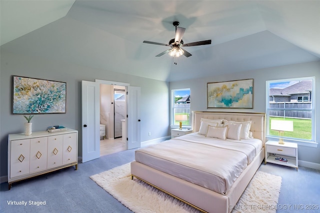 bedroom featuring carpet, vaulted ceiling, baseboards, ensuite bathroom, and ceiling fan