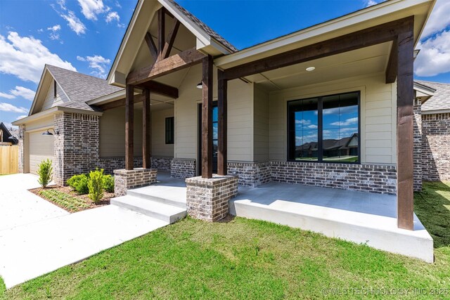 view of front of property with brick siding, a garage, a porch, concrete driveway, and a front lawn