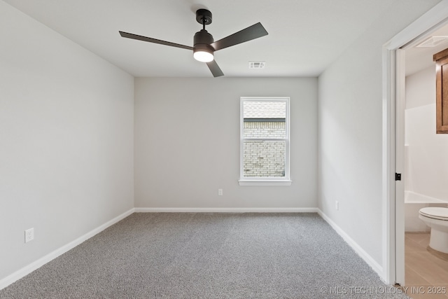 unfurnished bedroom featuring light carpet, baseboards, a ceiling fan, and connected bathroom