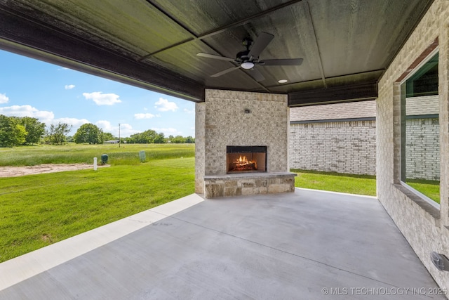 view of patio with a fireplace and a ceiling fan