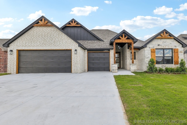 view of front of house with an attached garage, a front lawn, driveway, board and batten siding, and a shingled roof