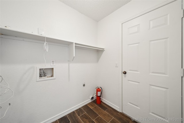 laundry area featuring hookup for a washing machine, baseboards, dark wood-type flooring, a textured ceiling, and hookup for an electric dryer