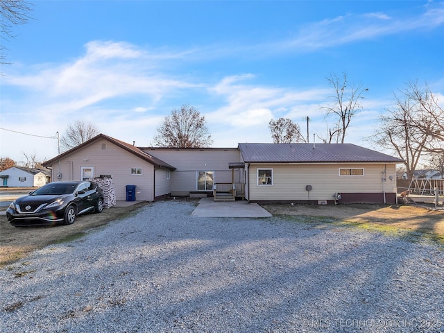 410 W B J Tunnell, Miami, OK 74354 - view of front facade with gravel driveway, metal roof, and a patio