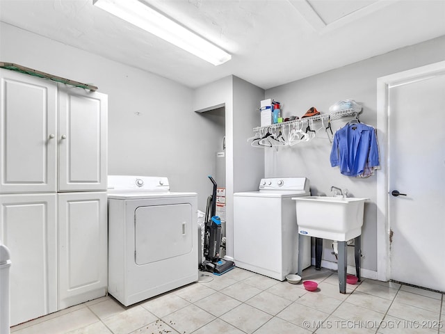 410 W B J Tunnell, Miami, OK 74354 - clothes washing area with cabinet space, washing machine and clothes dryer, and light tile patterned flooring