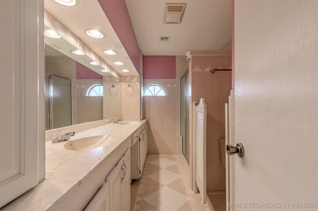 bathroom featuring a stall shower, double vanity, tile patterned flooring, and recessed lighting