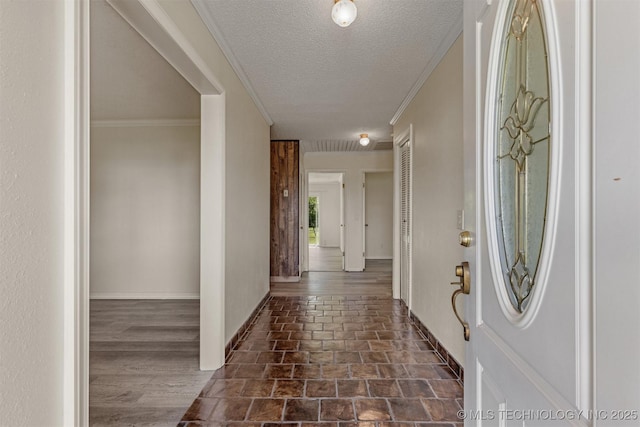 entryway featuring ornamental molding, baseboards, and a textured ceiling