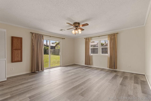 empty room with a ceiling fan, wood finished floors, a textured ceiling, crown molding, and baseboards