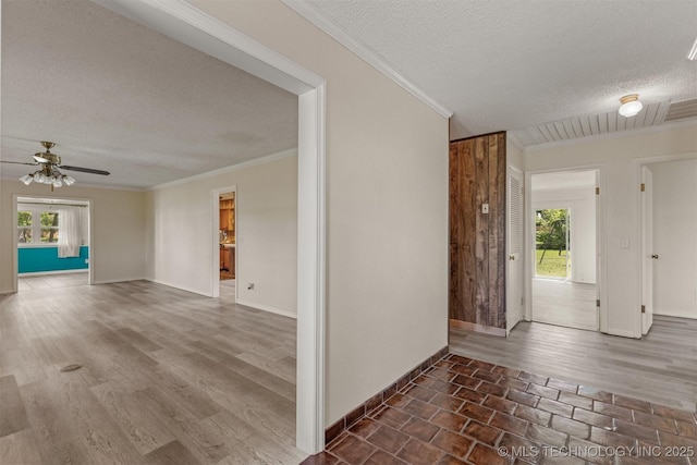 entrance foyer featuring a textured ceiling, a ceiling fan, crown molding, baseboards, and wood finished floors