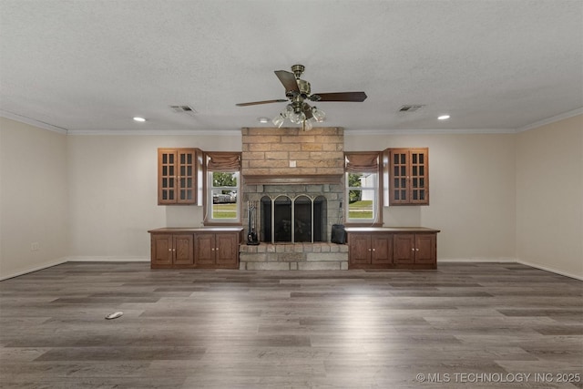 unfurnished living room featuring plenty of natural light, wood finished floors, ornamental molding, recessed lighting, and ceiling fan