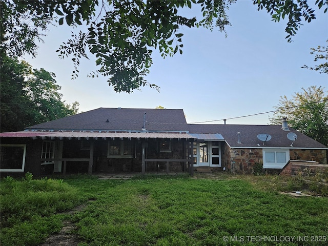 1435 E Oak St, Cushing, OK 74023 - rear view of house featuring a lawn, stone siding, and a chimney
