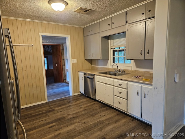 1435 E Oak St, Cushing, OK 74023 - kitchen featuring stainless steel dishwasher, a sink, ornamental molding, a textured ceiling, and dark wood-style floors