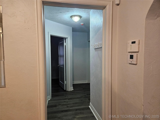 1435 E Oak St, Cushing, OK 74023 - hallway featuring dark wood-type flooring and baseboards